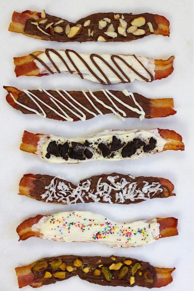 Chocolate covered bacon strips on white paper, dipped in dark and white chocolate with nuts and sprinkles