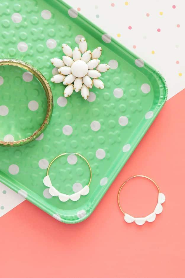 DIY scalloped statement hoop earrings, gold hoops with white scalloped trim on a mint polka dot tray and coral paper