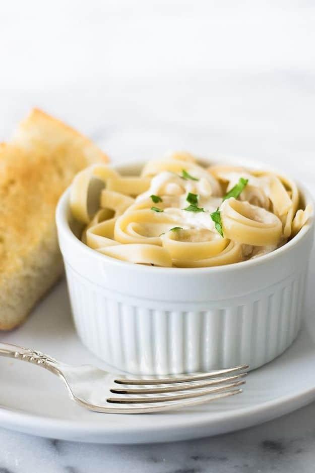 Quick fettuccine Alfredo for one in a shallow bowl, creamy parmesan sauce coating fresh fettuccine noodles