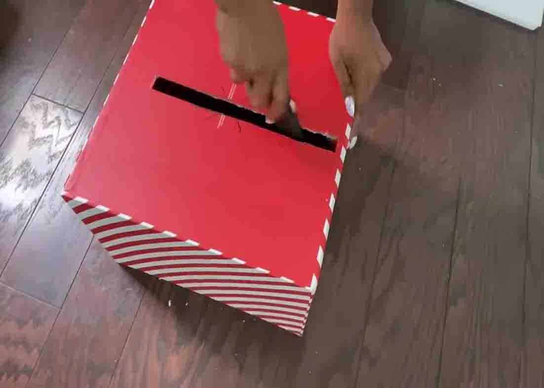 Making a hole into the empty box to insert the hoops inside