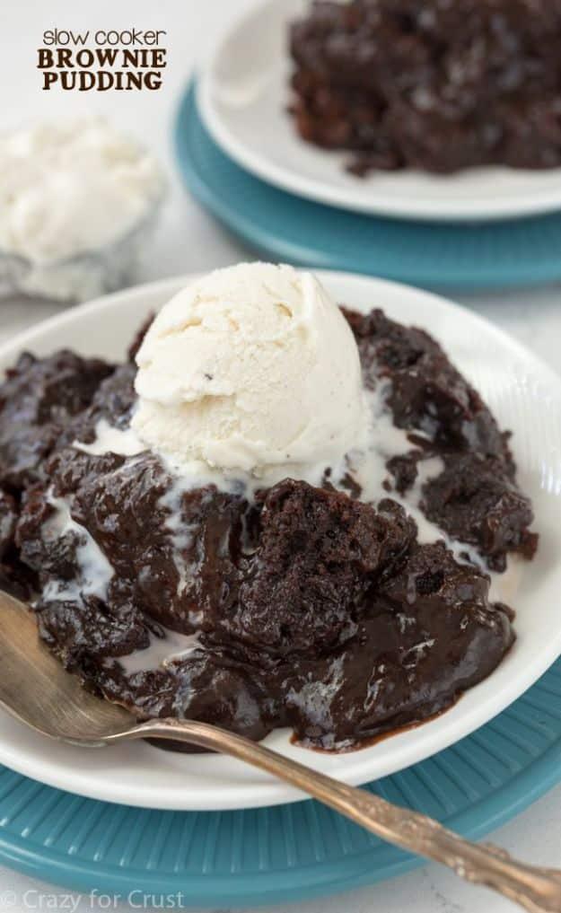 Slow cooker brownie pudding served in a bowl with melting vanilla ice cream over hot chocolate sauce