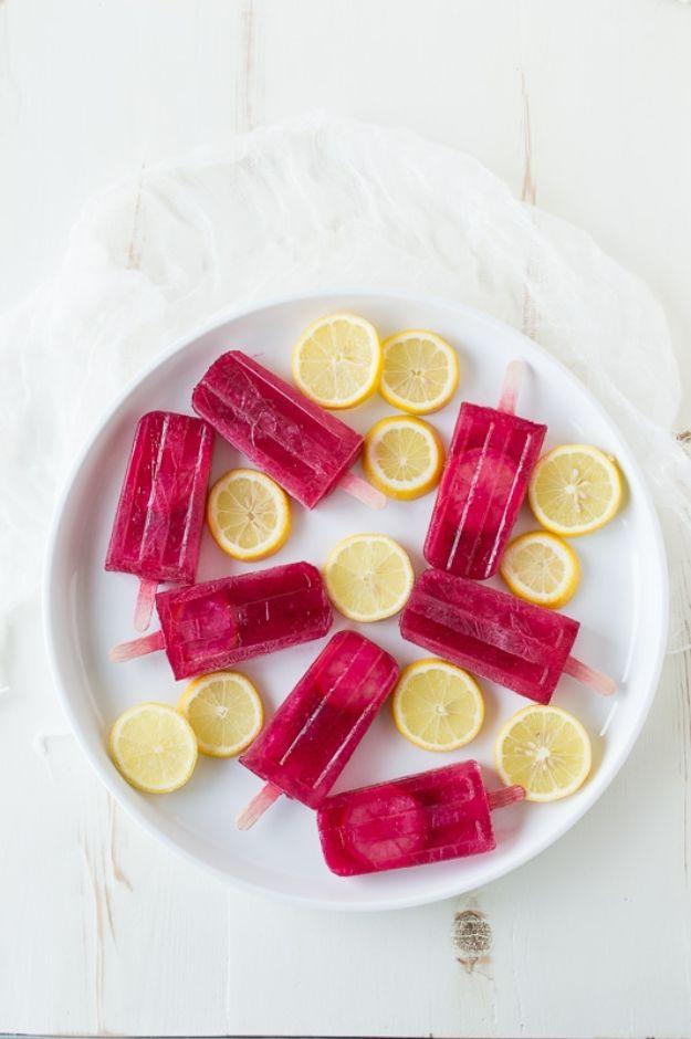 Passion tea lemonade popsicles frozen bright pink with a lemon slice in each pop on a tray, a copycat iced tea treat