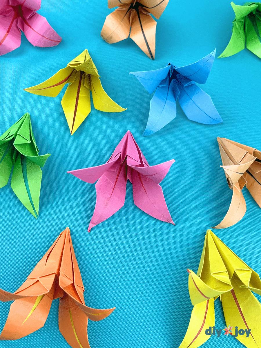 How to make paper flowers on video, a paper lily tutorial showing the folds in different colored origami paper