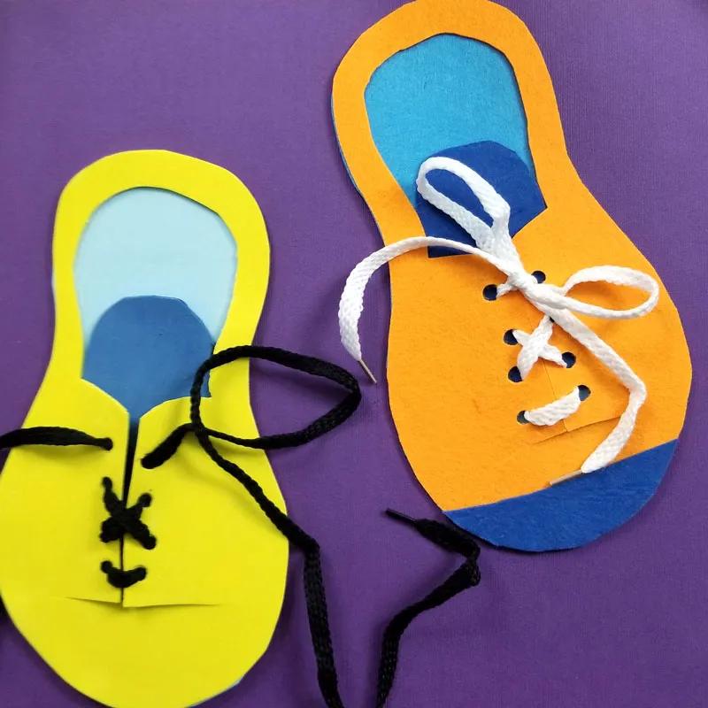 Two shoe tying practice toys cut from yellow and orange craft foam with punched eyelets and real black and white shoelaces