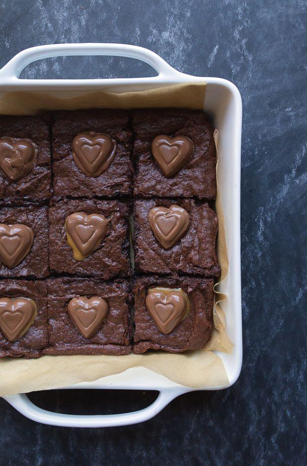 Caramel heart brownies in a white baking dish with nine chocolate hearts pressed evenly into the top