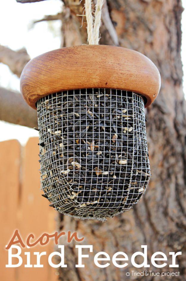 Acorn bird feeder with a round wooden bowl cap and quarter inch wire mesh body full of sunflower seed, hung on rope