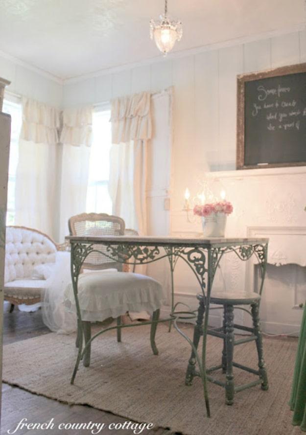 Cream drop cloth curtain panels with two deep gathered ruffles across the top, at corner windows in a white room