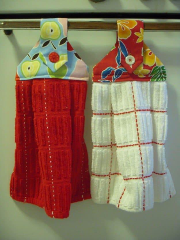 Hanging dishtowels, a kitchen sewing project with red and white towels topped in floral fabric buttoned to an oven bar