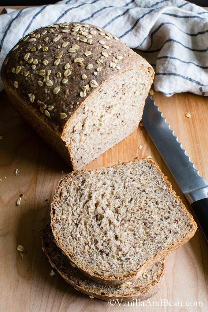 Multigrain bread loaf studded with oats, flax and sunflower seeds, sliced to show a soft dense crumb