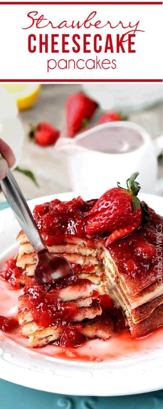Strawberry cheesecake pancakes cut open on a plate, drenched in fresh strawberry syrup with a whole berry