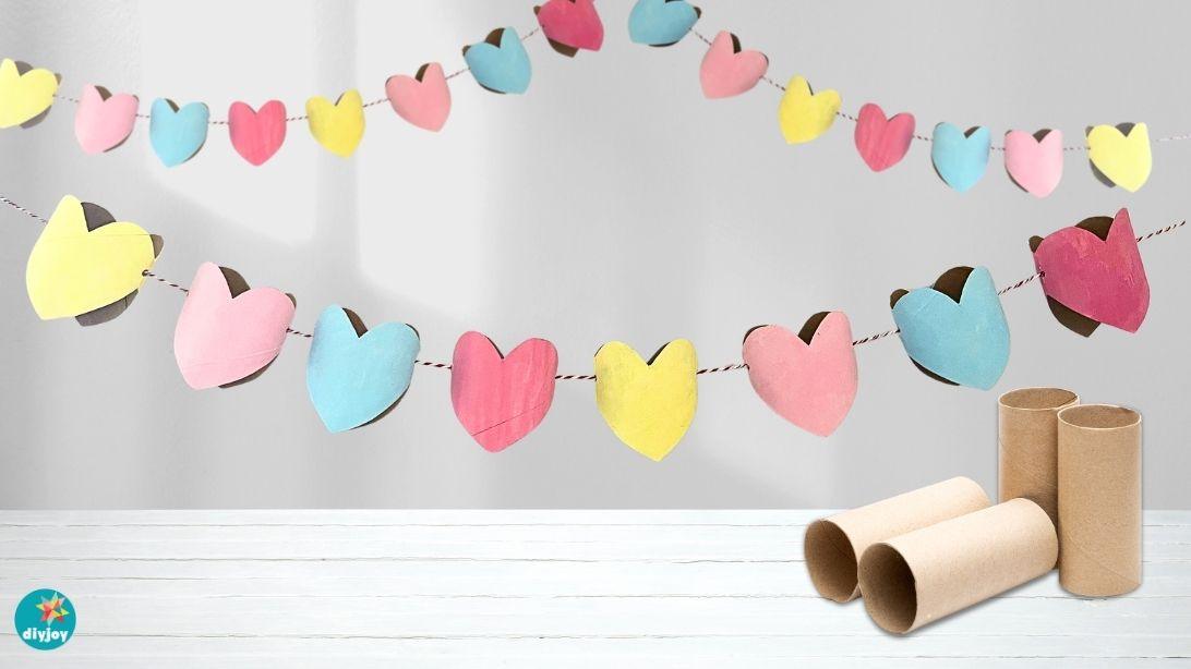 Hearts cut from recycled cardboard tubes and painted white, strung along twine across a bright open doorway