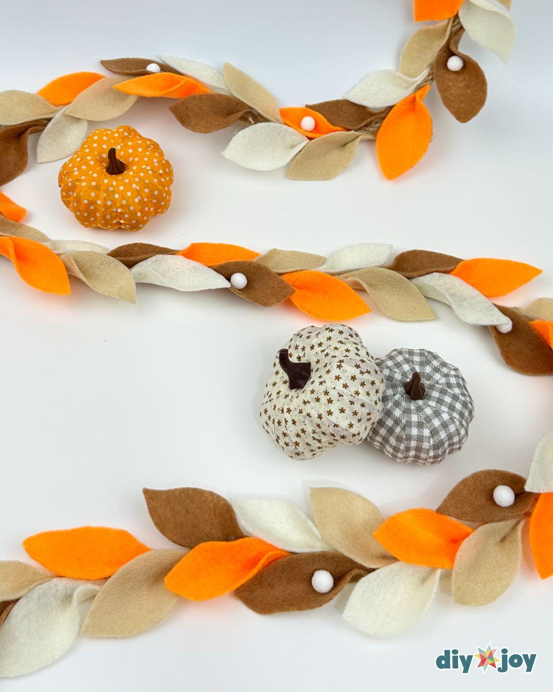 DIY fall garland made with felt leaves in your favorite autumn colors, hung on a fireplace or staircase.