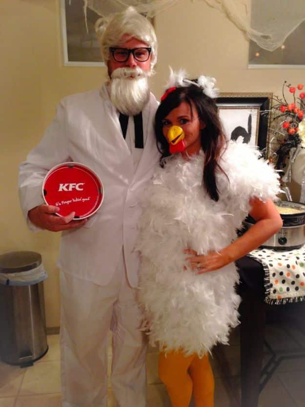 Colonel Sanders and chicken couples costume with a white suit and black string tie beside a feathered chicken