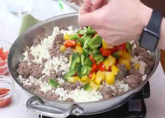 Adding the chopped bell peppers to the skillet