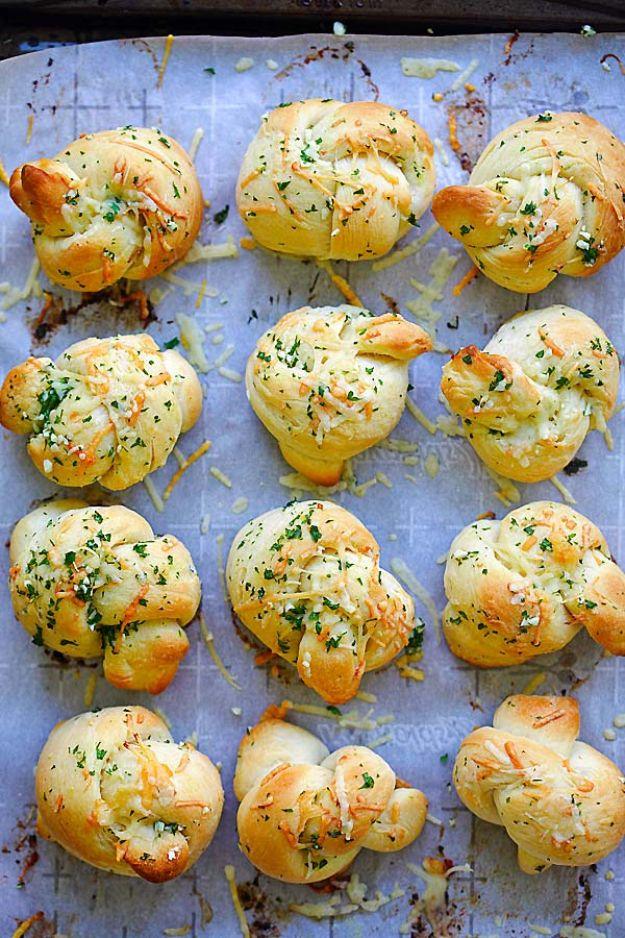 Garlic parmesan dinner rolls tied into knots and brushed with herb butter and shredded parmesan cheese