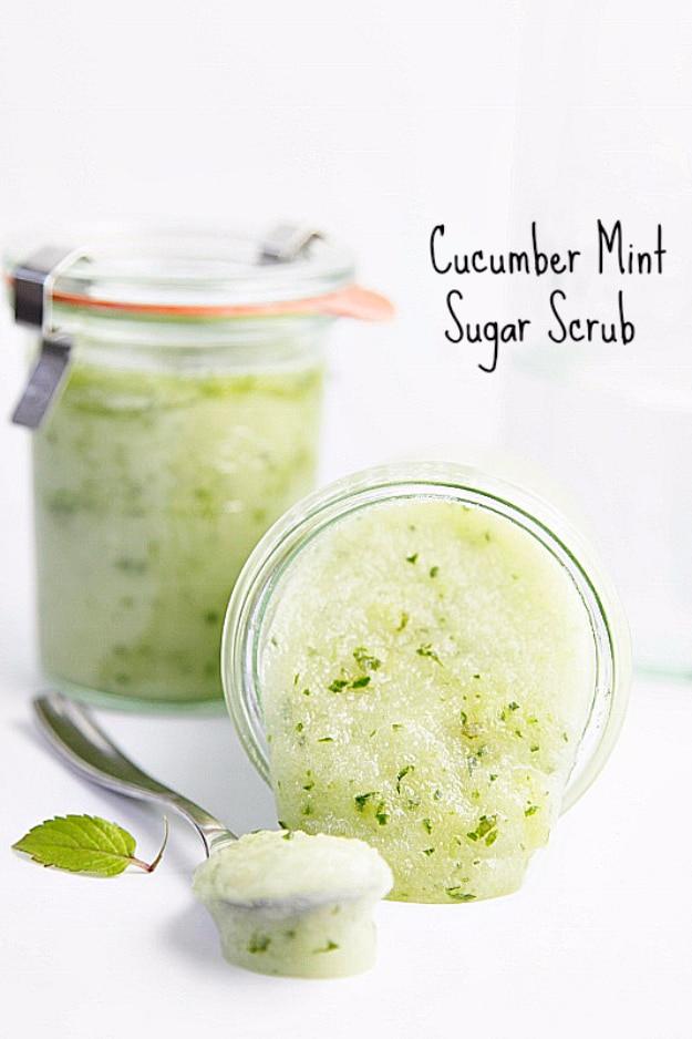 DIY cucumber mint sugar scrub, a pale green scrub in two glass jars with a fresh mint sprig and a spoon