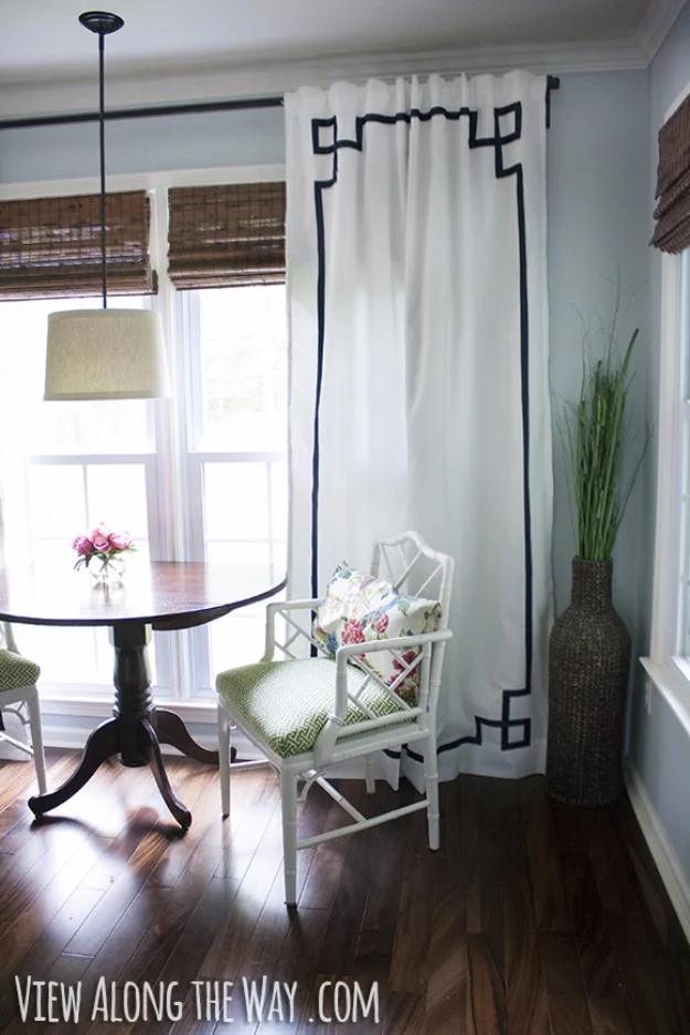 DIY curtain panel with a navy Greek key border ironed onto white fabric, hanging beside a breakfast table and bamboo shades