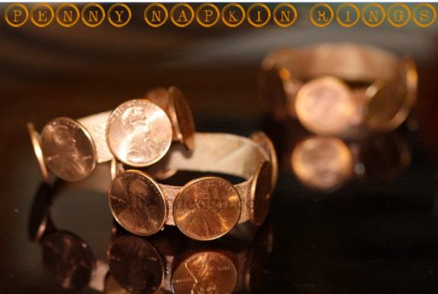 Penny napkin rings made from copper coins on a dark reflective table, under typeset lettering at the top