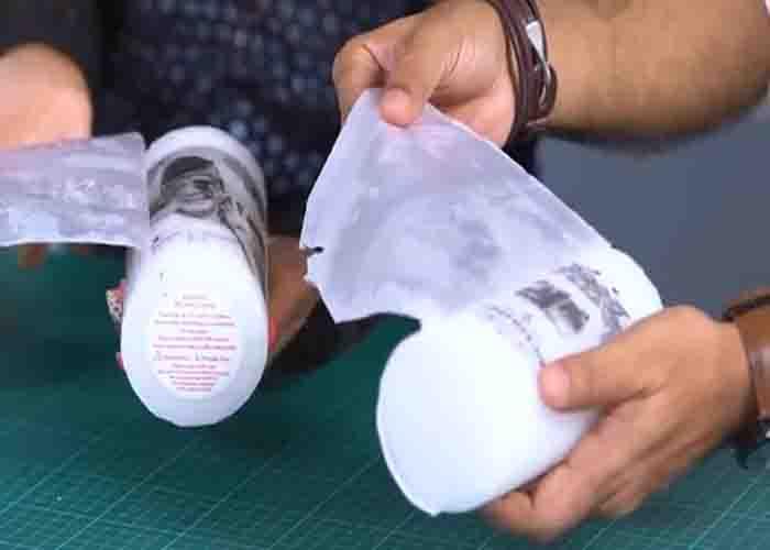 Peeling off the wax paper to reveal the transferred image on the candle