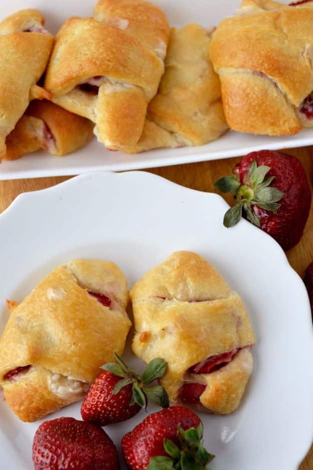 Strawberry cream crescent rolls filled with sweetened cream cheese and sliced fresh strawberries on a tray