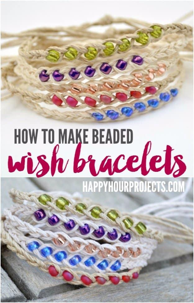 Three beaded wish bracelets on waxed cotton cord, tied to small kraft cards and laid out on a weathered wooden board