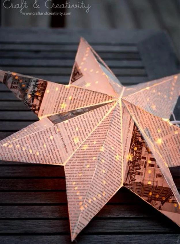 Old book lantern made from a paper star covered in book pages, lit from within and glowing on a dark table