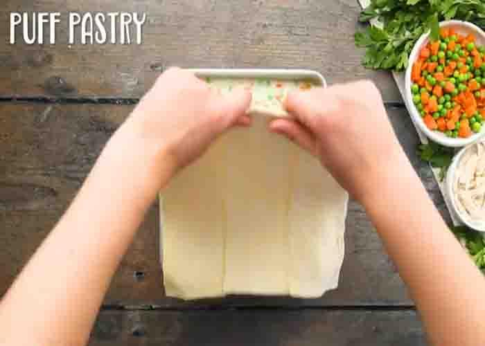 Covering the chicken pot pie with puff pastry