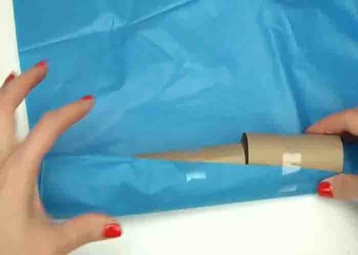 Wrapping the tissue rolls with tissue paper to make the DIY new year party poppers
