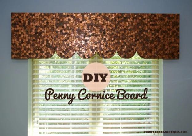 Penny cornice board with scalloped lower edge covered in copper coins, mounted above a white window blind