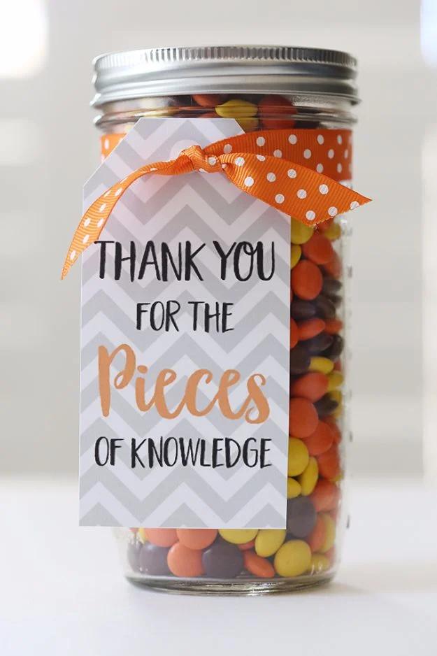 Mason jar teacher's gift free printable tag in grey chevron reading thank you for the pieces, on a jar of orange sweets