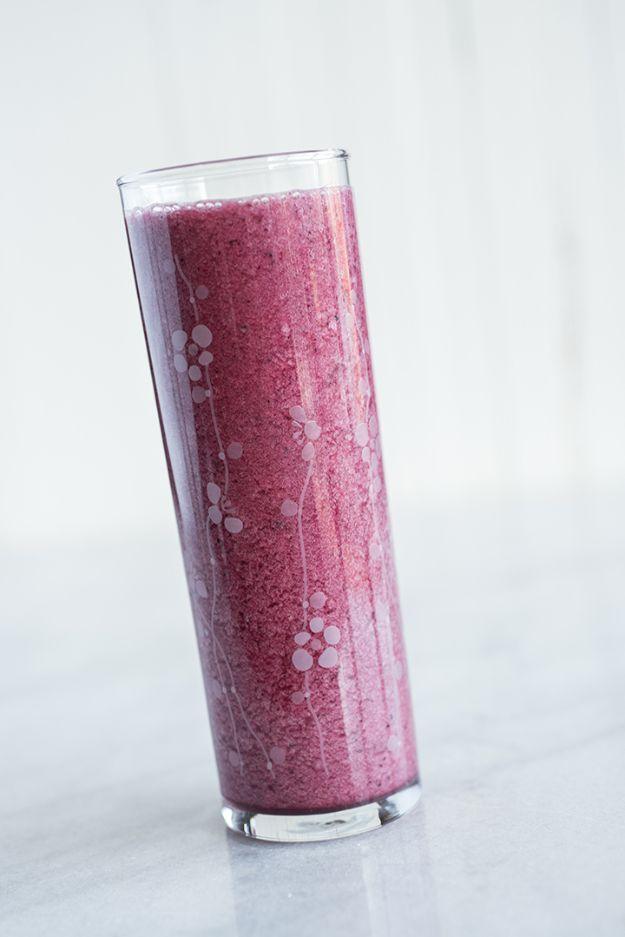 Apple cider vinegar detox juice in a tall patterned glass, thick and deep purple, on a marble counter