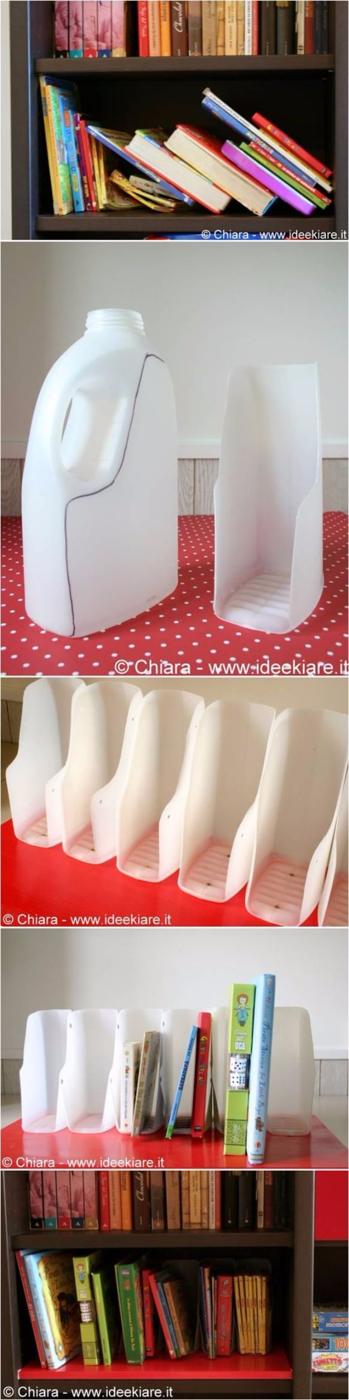Five white magazine file dividers cut from plastic jugs mounted on a red board, holding children's books upright on a shelf
