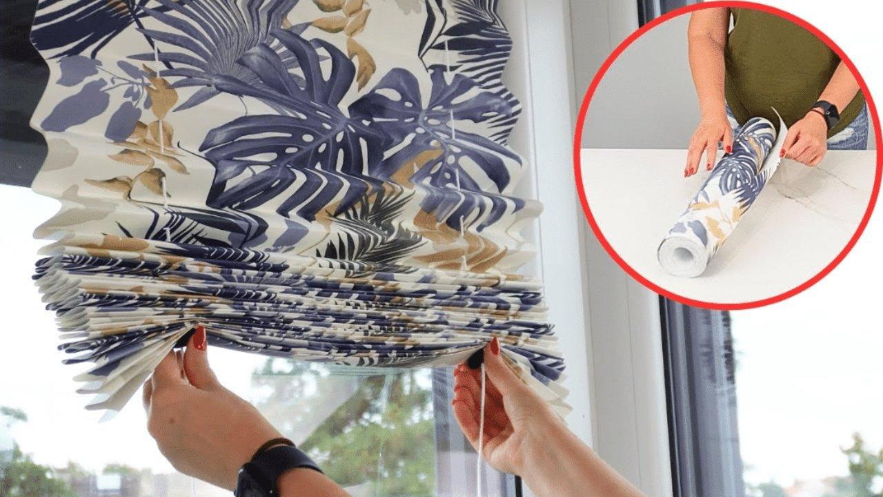 DIY wallpaper blinds, hands drawing up a pleated navy and gold palm print blind at a window with a wallpaper roll inset