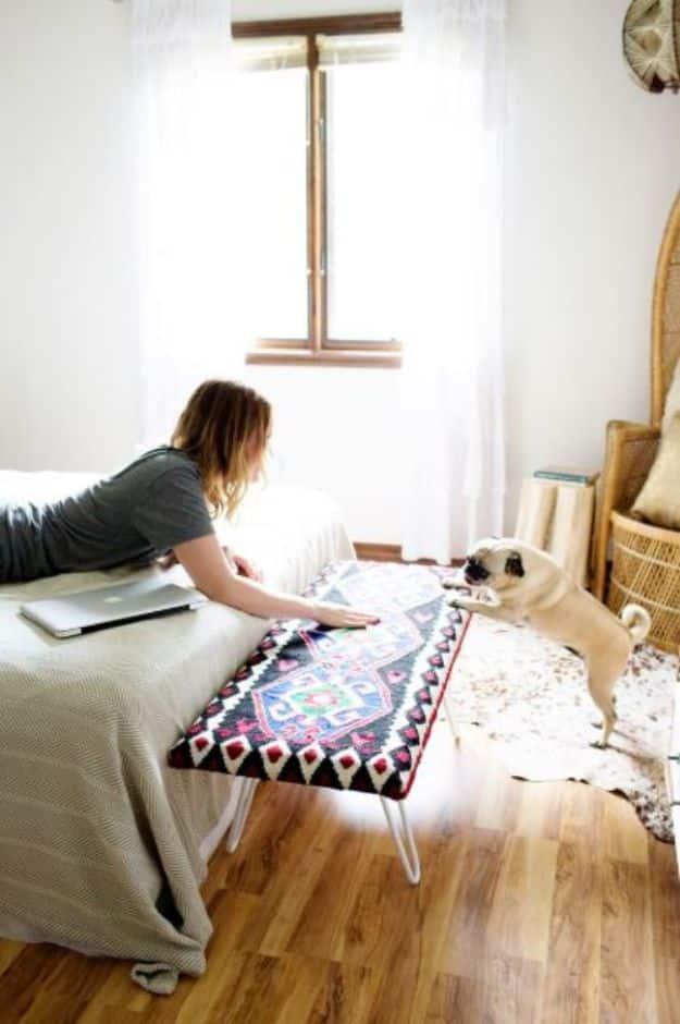 Colorful patterned bench with hairpin legs at the foot of a bed in a bright bedroom with a dog nearby