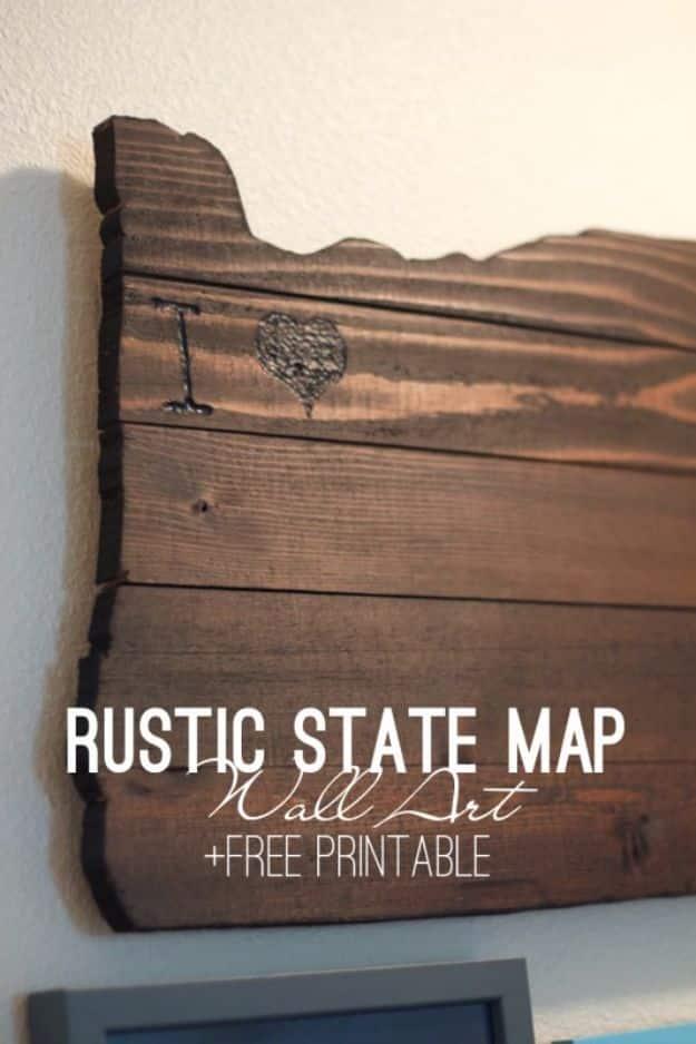 Rustic wall art of dark stained boards with a state map outline wood burned into the surface, hung on a cream wall