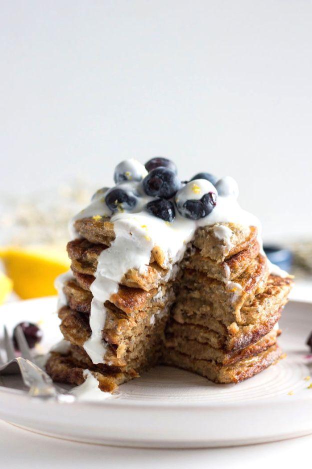 Blueberry chia seed pancakes stacked and topped with lemon yogurt and fresh blueberries, one slice cut out