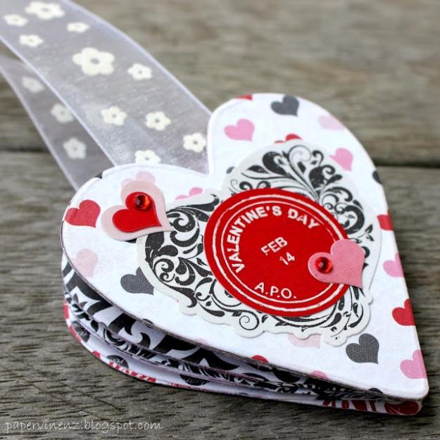 Handmade Valentine bookmark with a heart and a ribbon tail tucked into an open book on a table to make at home