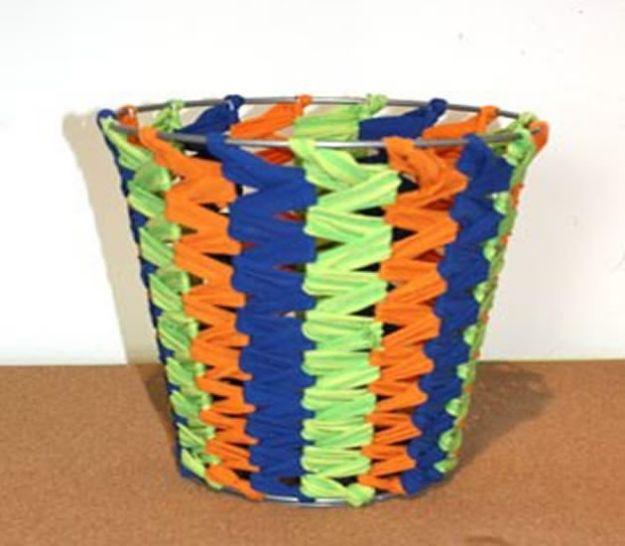 Wire frame trash can woven with navy, orange and lime green jersey strips over and under the vertical spokes