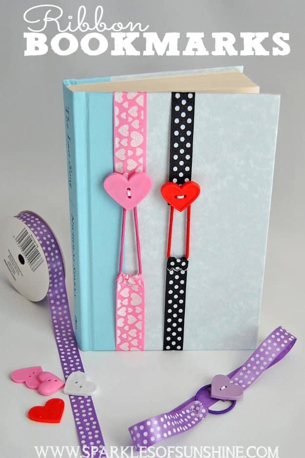 A slim satin ribbon bookmark with a stretchy elastic loop and a pearl button, resting across the pages of an open paperback