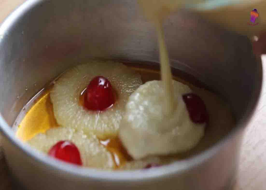 Pouring the bread mixture over the caramel and sliced pineapples