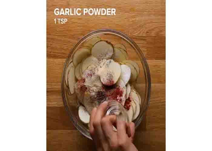 Seasoning the potato slices for the breakfast cups recipe