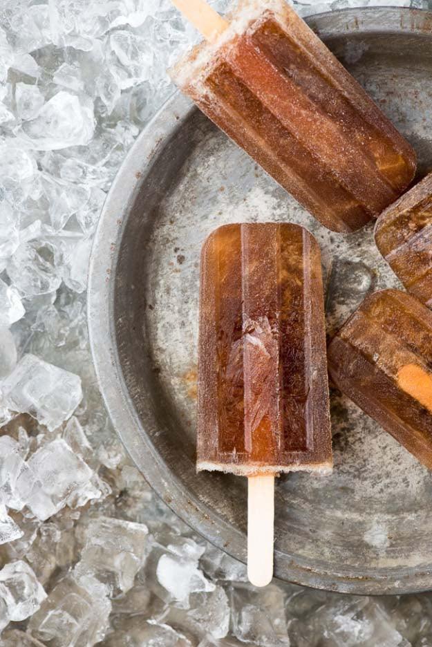 Jack and Mexican Coke popsicles, amber whiskey and cola ice pops in a galvanized bowl of crushed ice