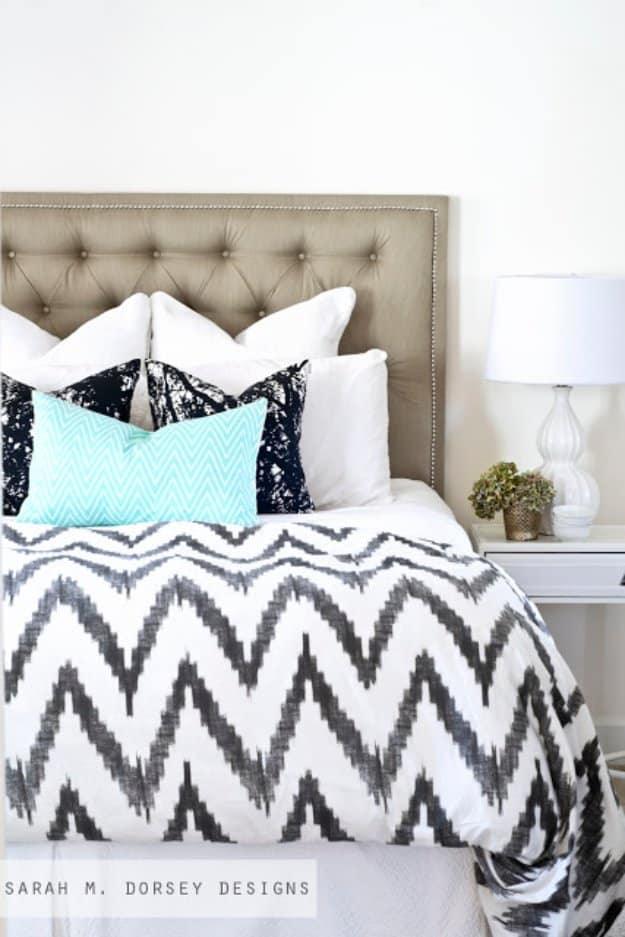 Tufted headboard with nailhead, a tan diamond tufted headboard with silver nailhead trim over chevron bedding