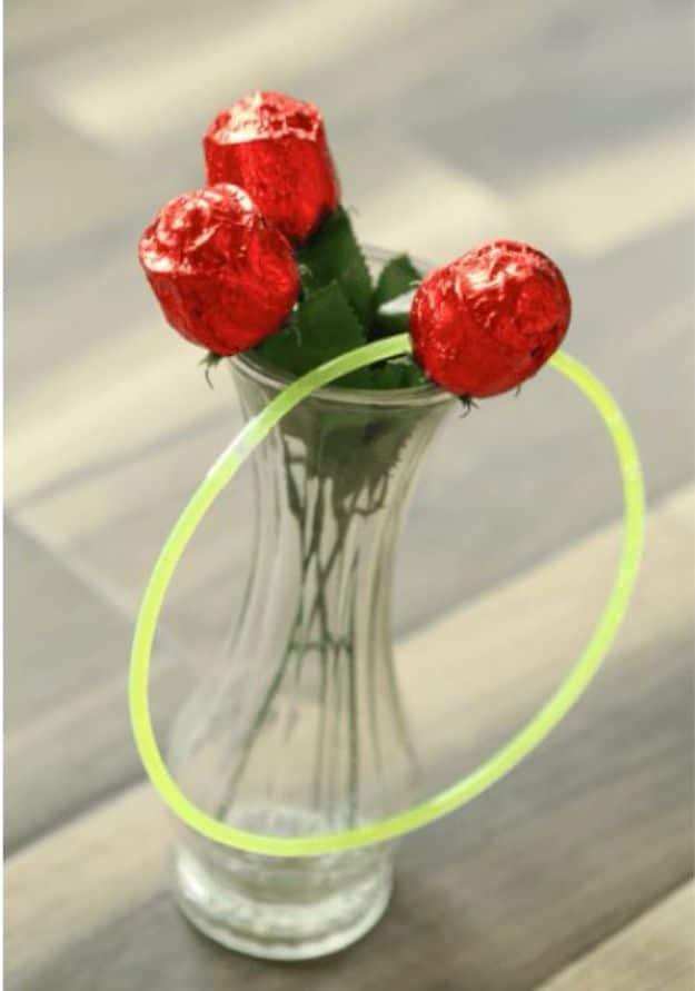 Ring around the roses Valentine party game with pink rings being tossed toward bottles topped with roses