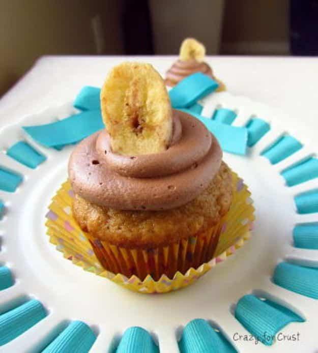 Elvis style peanut butter banana cupcake with a swirl of chocolate frosting and a dried banana chip on top