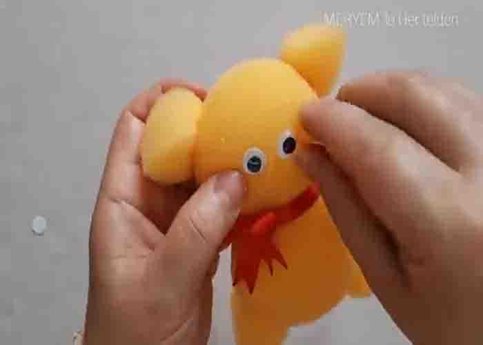 Gluing the googly eyes to the sponge teddy bear