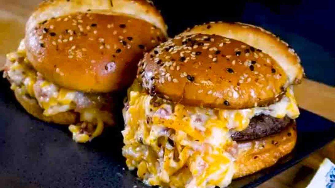 Crack burger on a toasted bun with a cheddar bacon ranch spread and browned griddle onions ready for the grill
