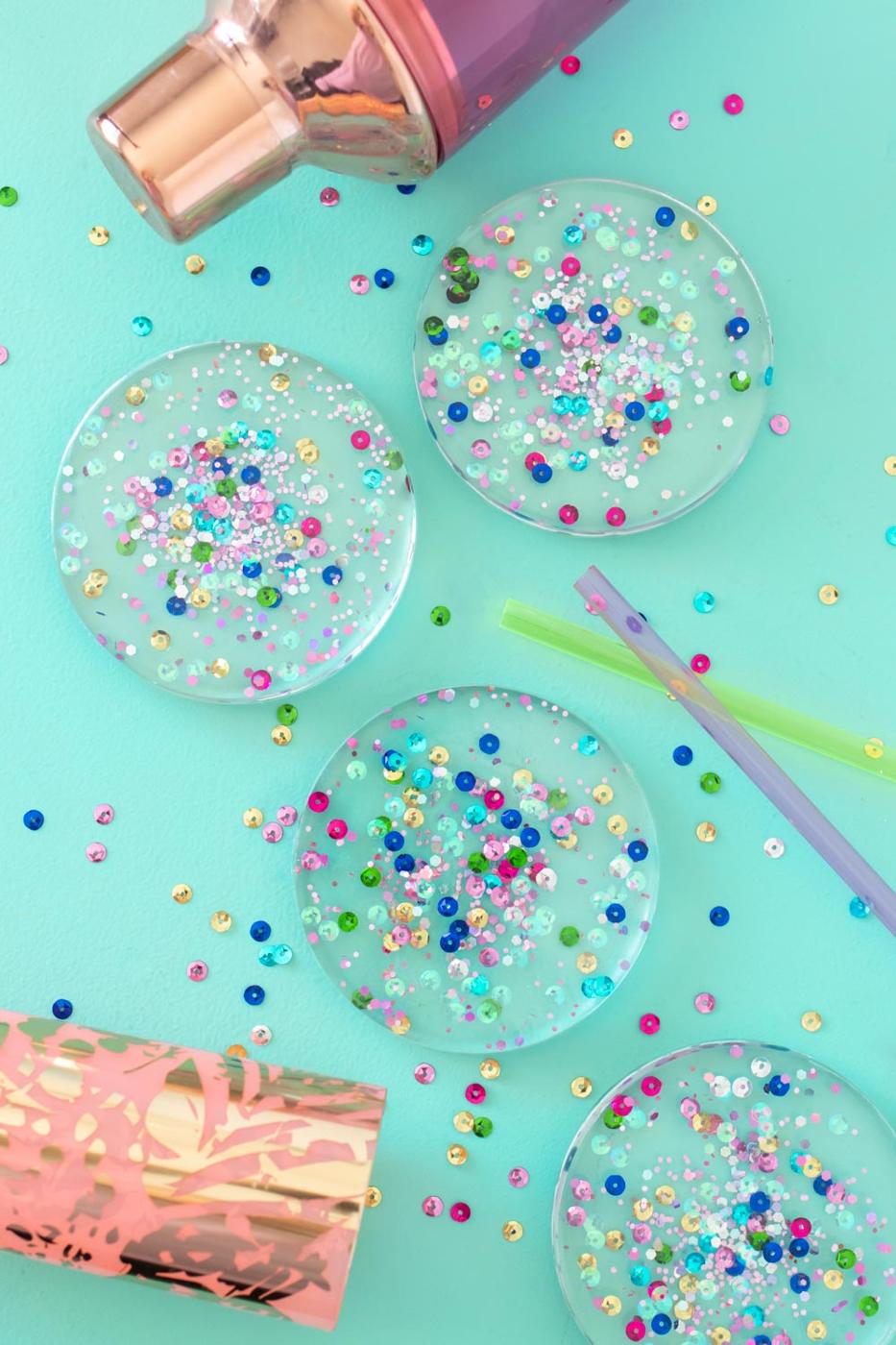 Confetti resin coasters, four clear round coasters set with pastel sequins and glitter on a mint surface