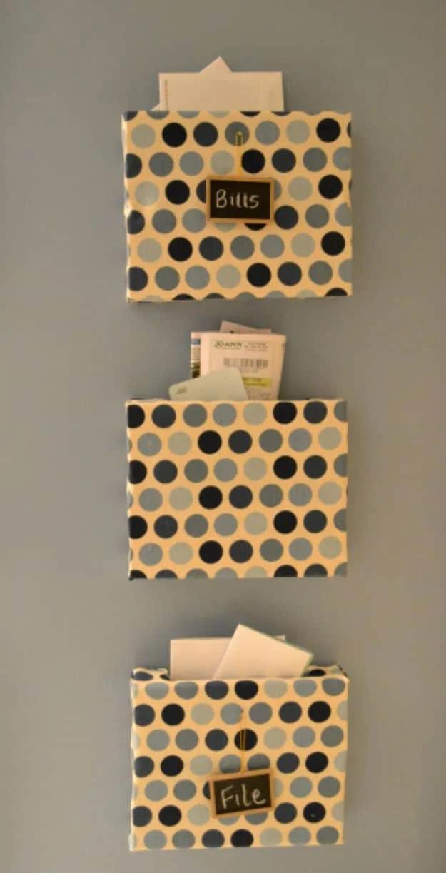 Three wall mounted boxes wrapped in black, gray and cream polka dot fabric with small chalkboard labels reading bills, file