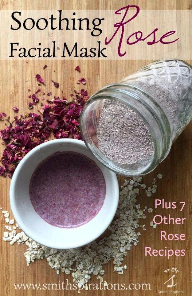 Soothing rose facial mask, a white bowl of pink mask paste on a bamboo board with a tipped jar of rose clay and dried petals